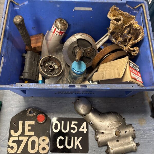 Royal Enfield twin timing cover in a box of motorcycle parts.