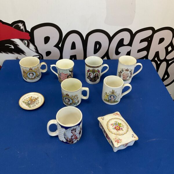 Collection of Royal Family commemorative mugs on display.