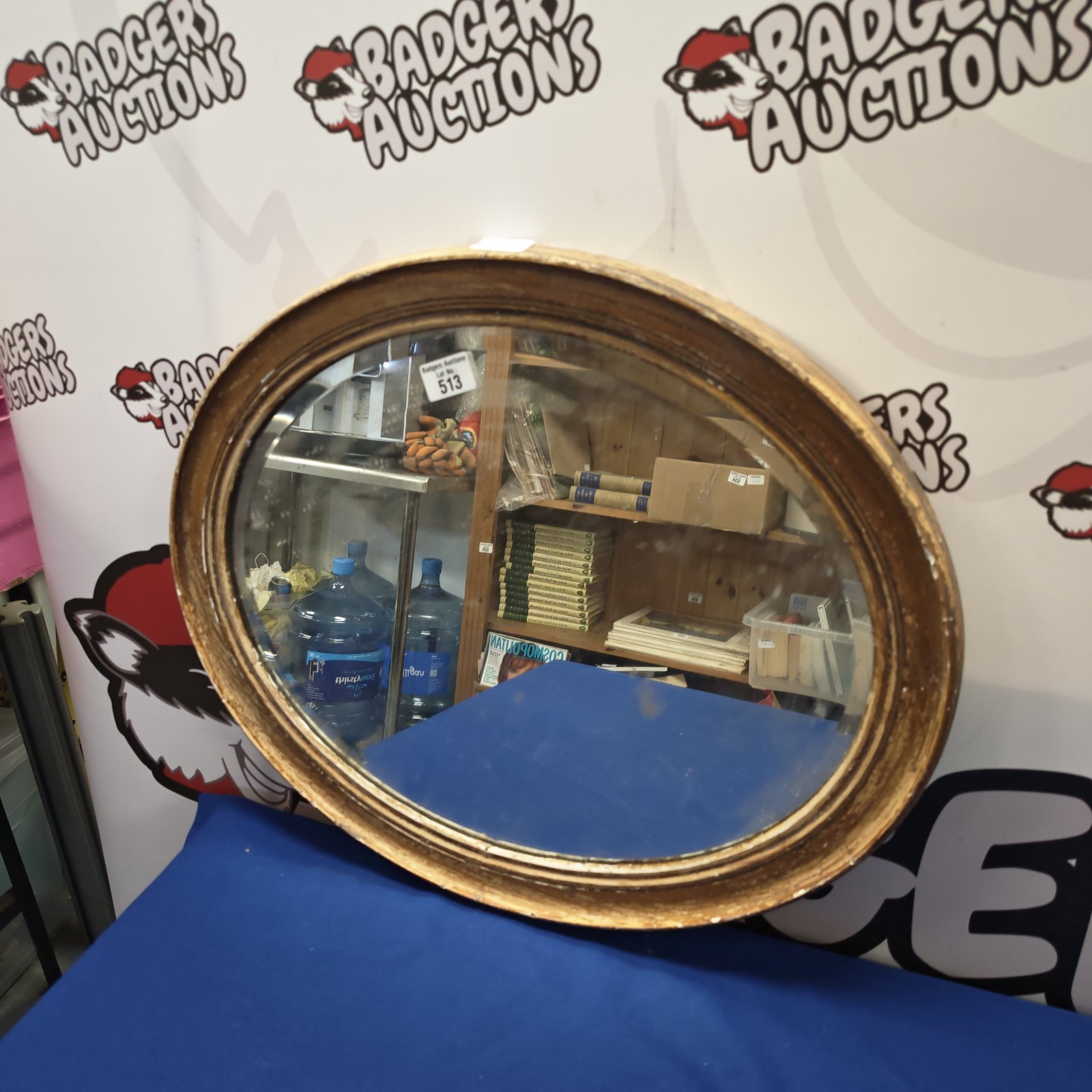 Rustic oval wall mirror with a weathered frame, vintage style.