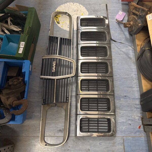Pair of used Saab and Jeep car front grilles for automotive restoration.
