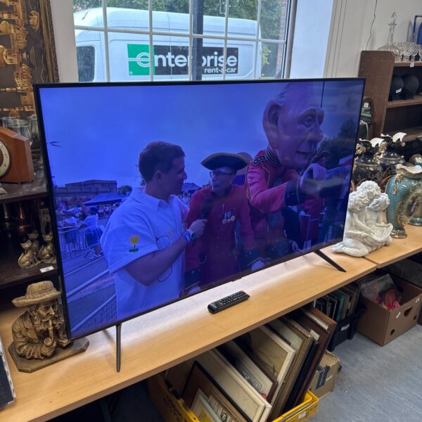 Samsung 55 inch smart TV with remote control on display.