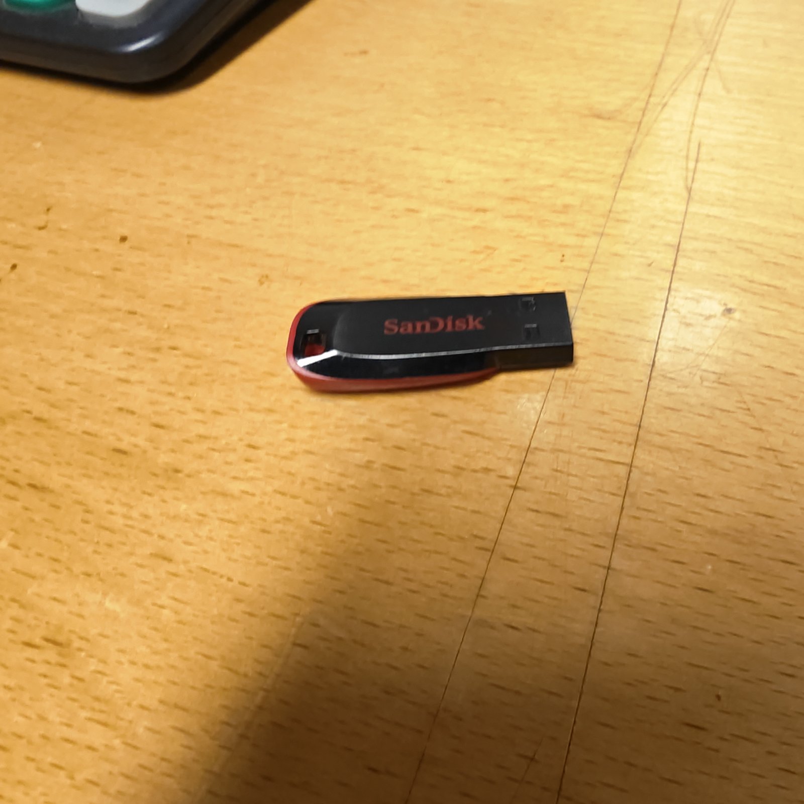 Red and black SanDisk USB drive for portable data storage.
