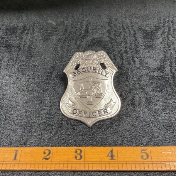 Vintage silver security officer metal badge with scales.