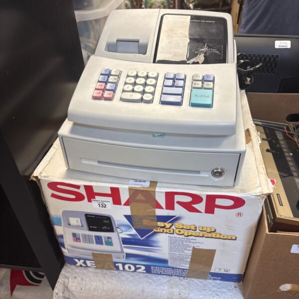 Vintage Sharp XE-A102 cash register with keys, side view.