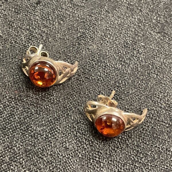 Close-up of 925 silver mounted amber stud earrings.