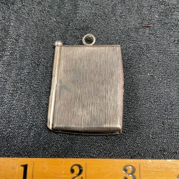 Antique silver chatelaine notepad with ribbed texture and pencil.