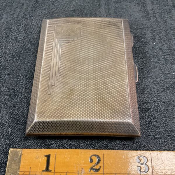 Vintage sterling silver cigarette case with ruler for scale.