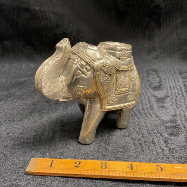 Antique silver elephant figurine with detailed saddle design.