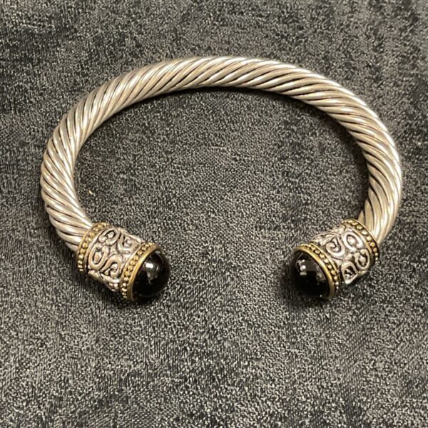 Silver and gold twisted wire cuff bracelet with black cabochons.