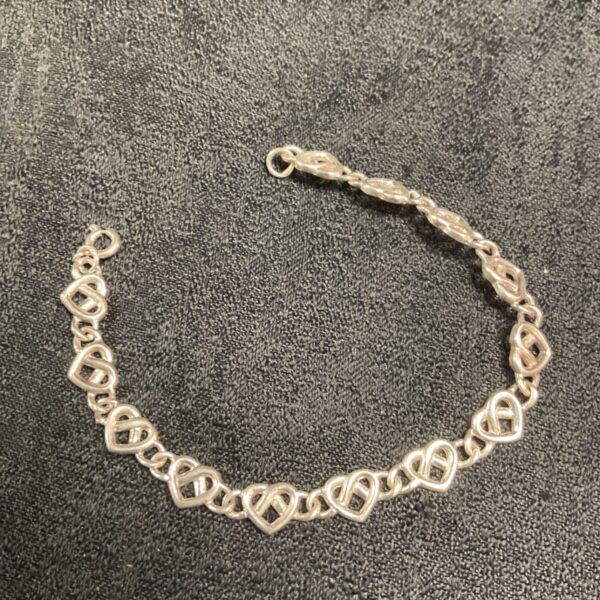 Delicate silver heart link bracelet, a charming fashion accessory.
