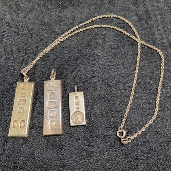 Hallmarked silver ingots featuring St Christopher and jubilee designs.
