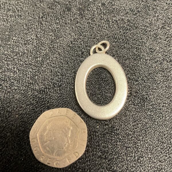 Brushed silver O pendant on a delicate chain.