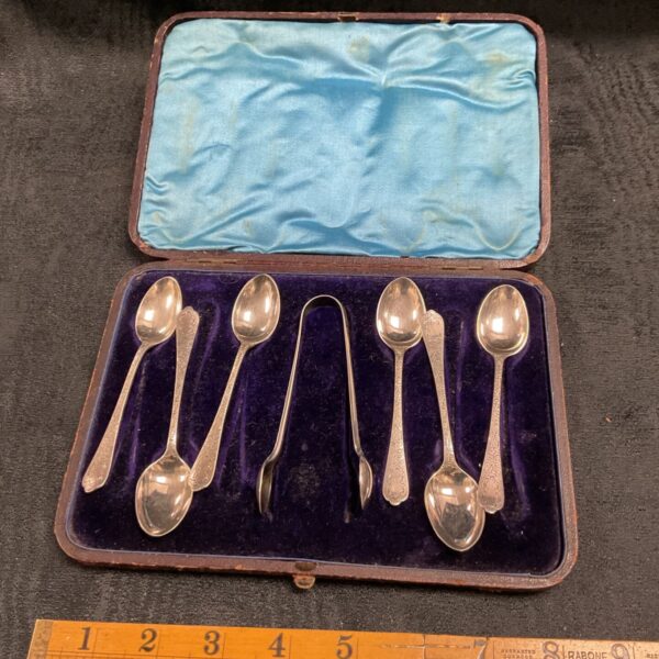 Vintage silver plate teaspoons and sugar tongs in a box.