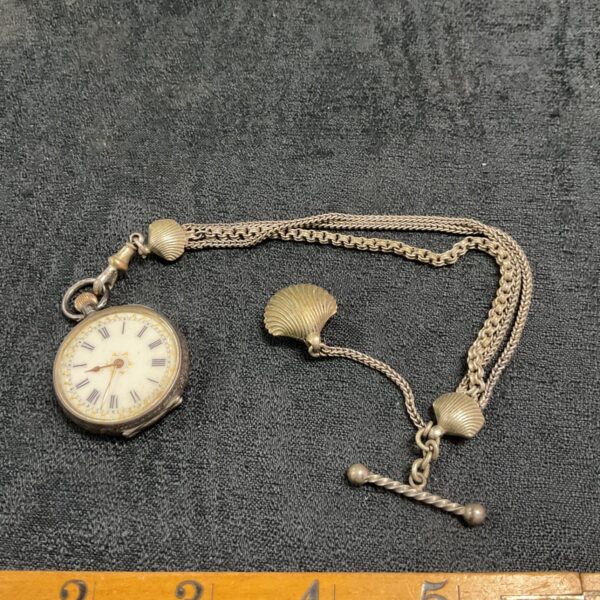 Antique silver ladies pocket watch with clam shell chain.