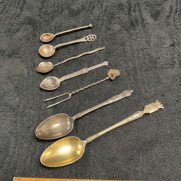Antique silver spoon collection with decorative handles.