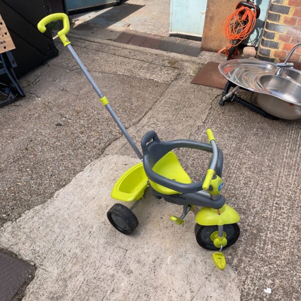Green and blue SmarTrike tricycle with push handle.
