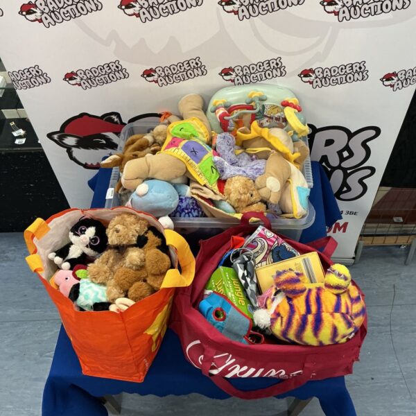 A colourful bundle of soft toys in bags and a box.