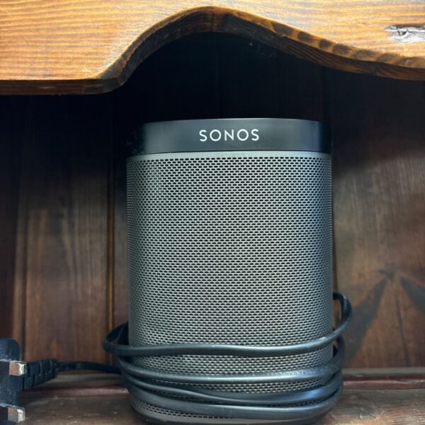 White Sonos Play 1 smart speaker with power cable attached.