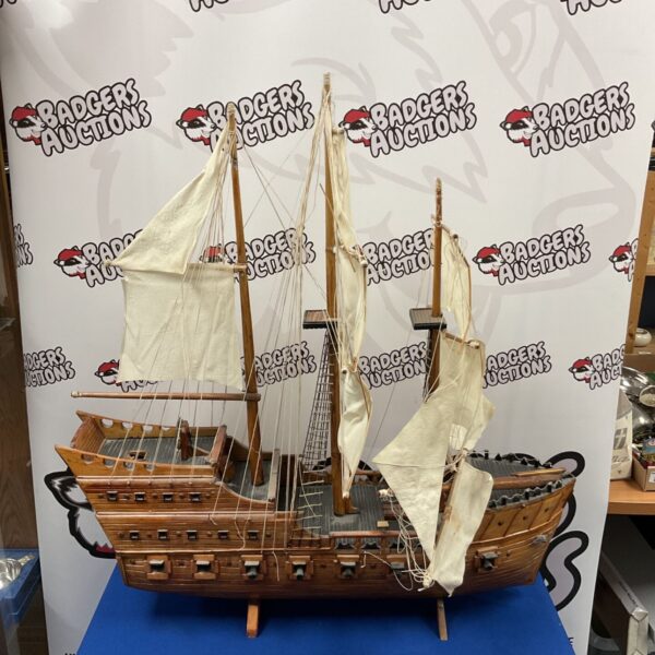 Detailed wooden model of a Spanish galleon ship with white sails.