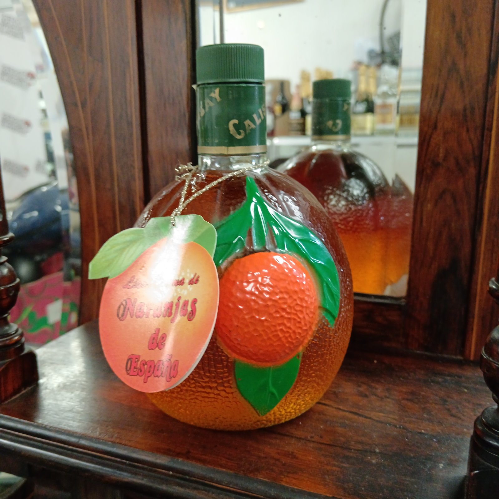 Vintage Spanish orange liqueur bottle with unique orange shape.