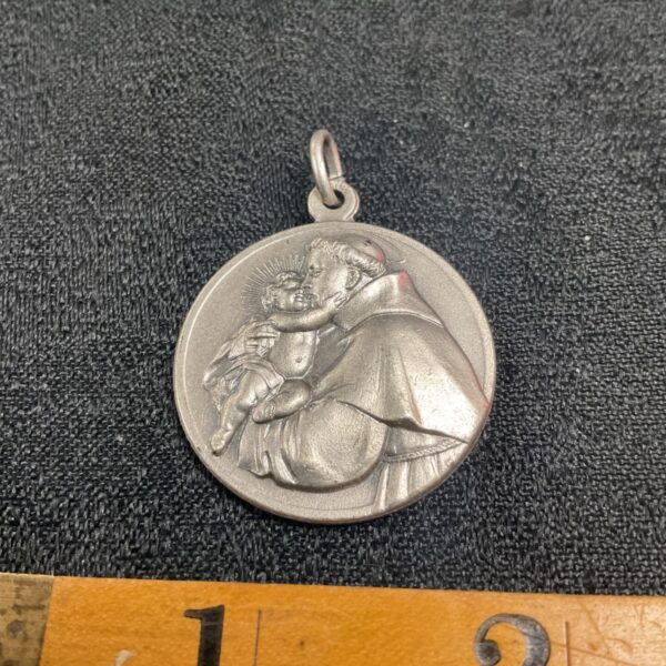 Vintage silver-toned St Anthony pendant with detailed relief.