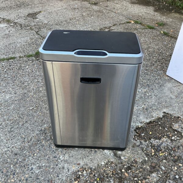 Stainless steel kitchen bin with a black lid and foot pedal.