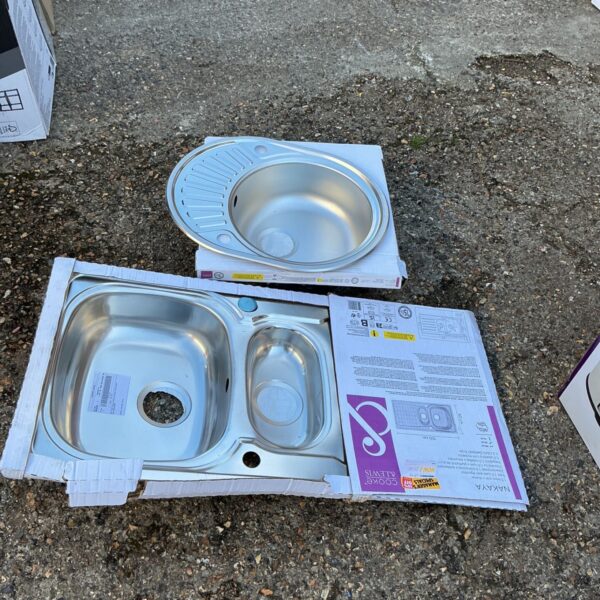 Stainless steel kitchen sink set with double bowls, showing signs of wear.