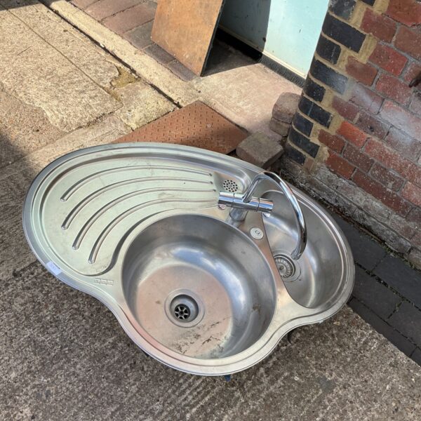 Unusual stainless steel sink with tap, vintage kitchen fixture.