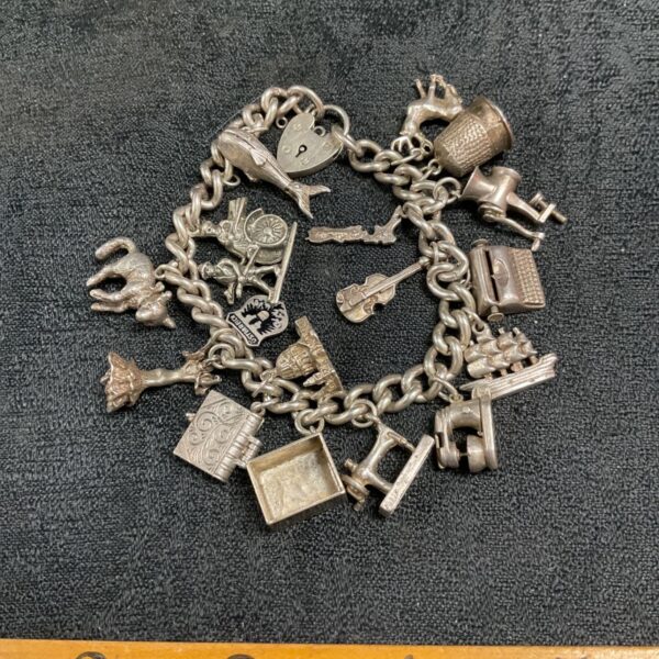 Vintage sterling silver charm bracelet with detailed charms.