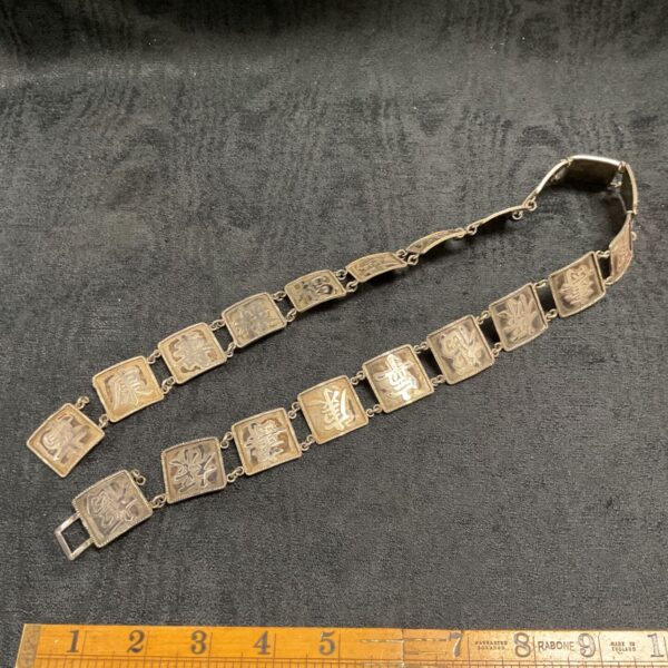 Vintage sterling silver bracelet with Chinese characters displayed on square links.