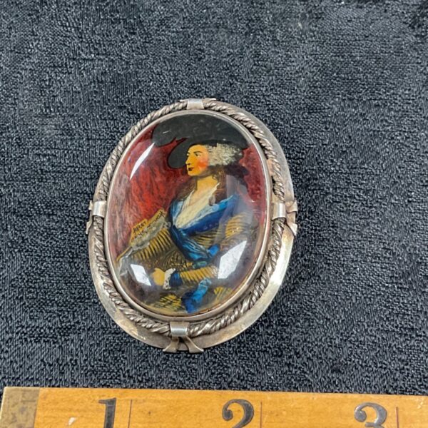 Antique sterling silver brooch with a hand-painted portrait.