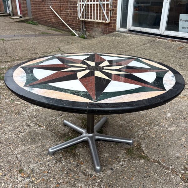 Round stone inlaid patio table with geometric design.