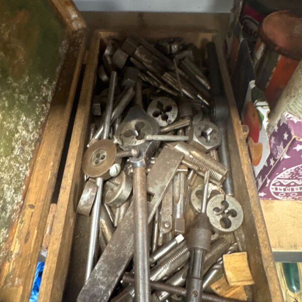 Vintage tray of taps and dies for metalworking projects.