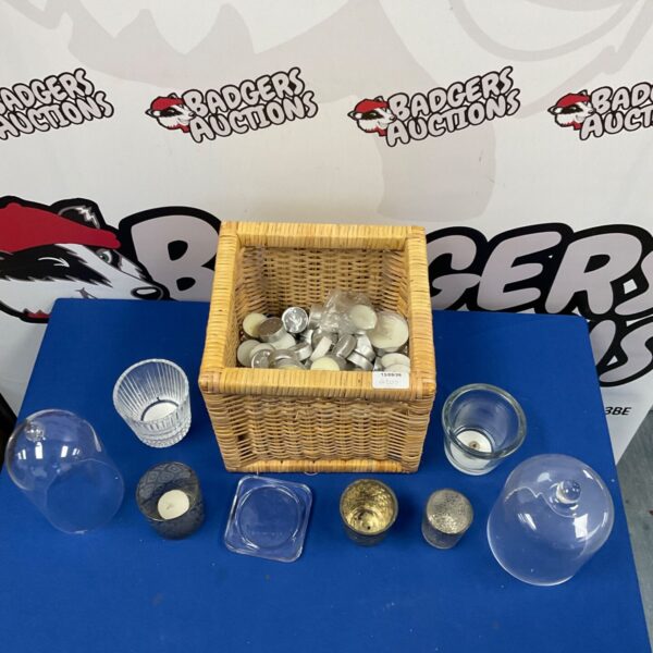 Assorted tea light holders and candles in a woven basket.