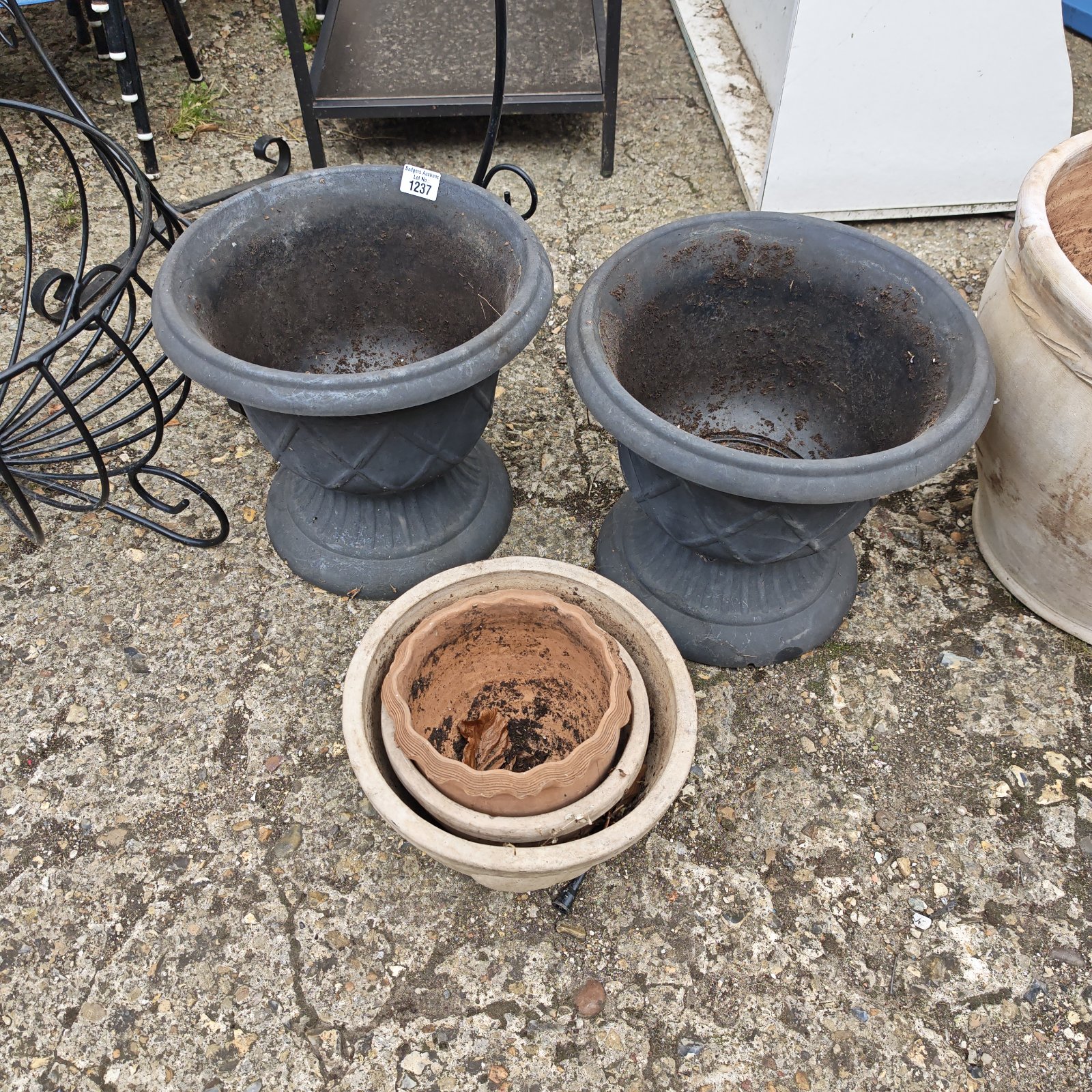 Bundle of weathered terracotta plant pots for garden use.