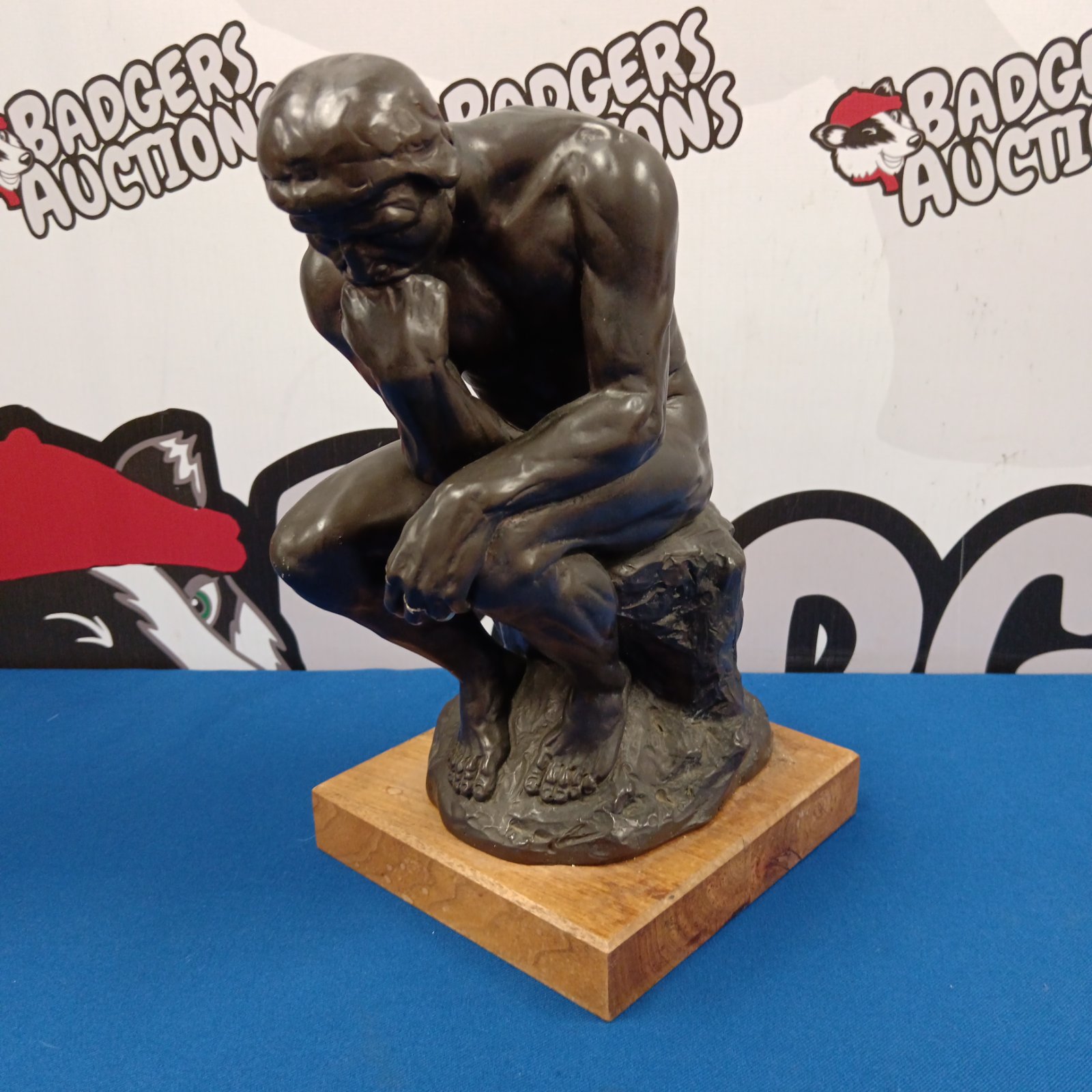 Bronze finish The Thinker statue replica on wooden base.