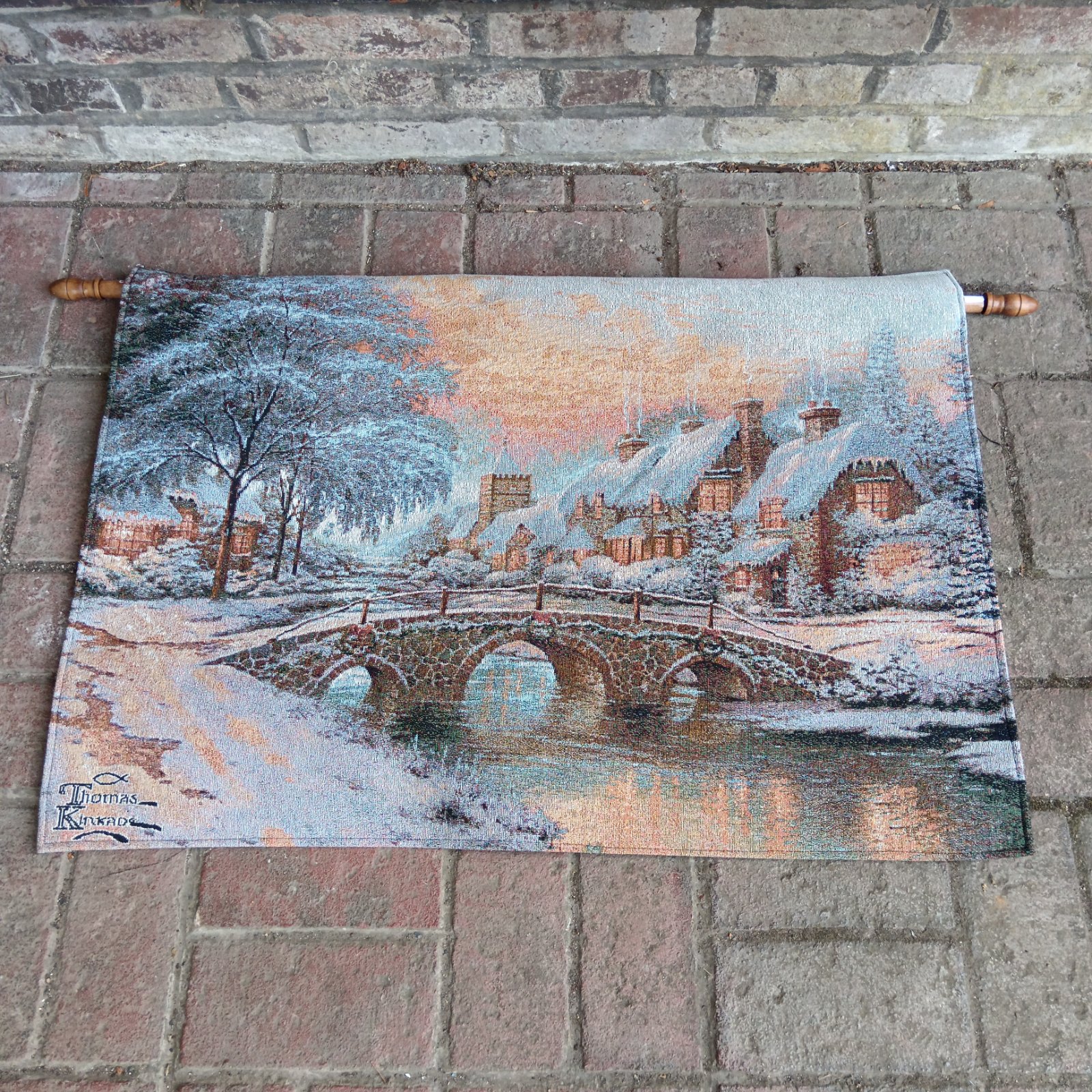 Thomas Kinkade cobblestone Christmas wall hanging with snow-covered village.