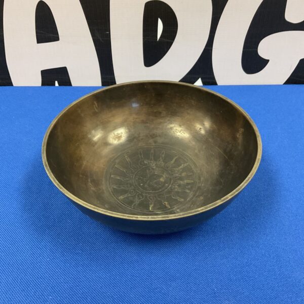 Antique Tibetan singing bowl with sun design, bronze ritual instrument.