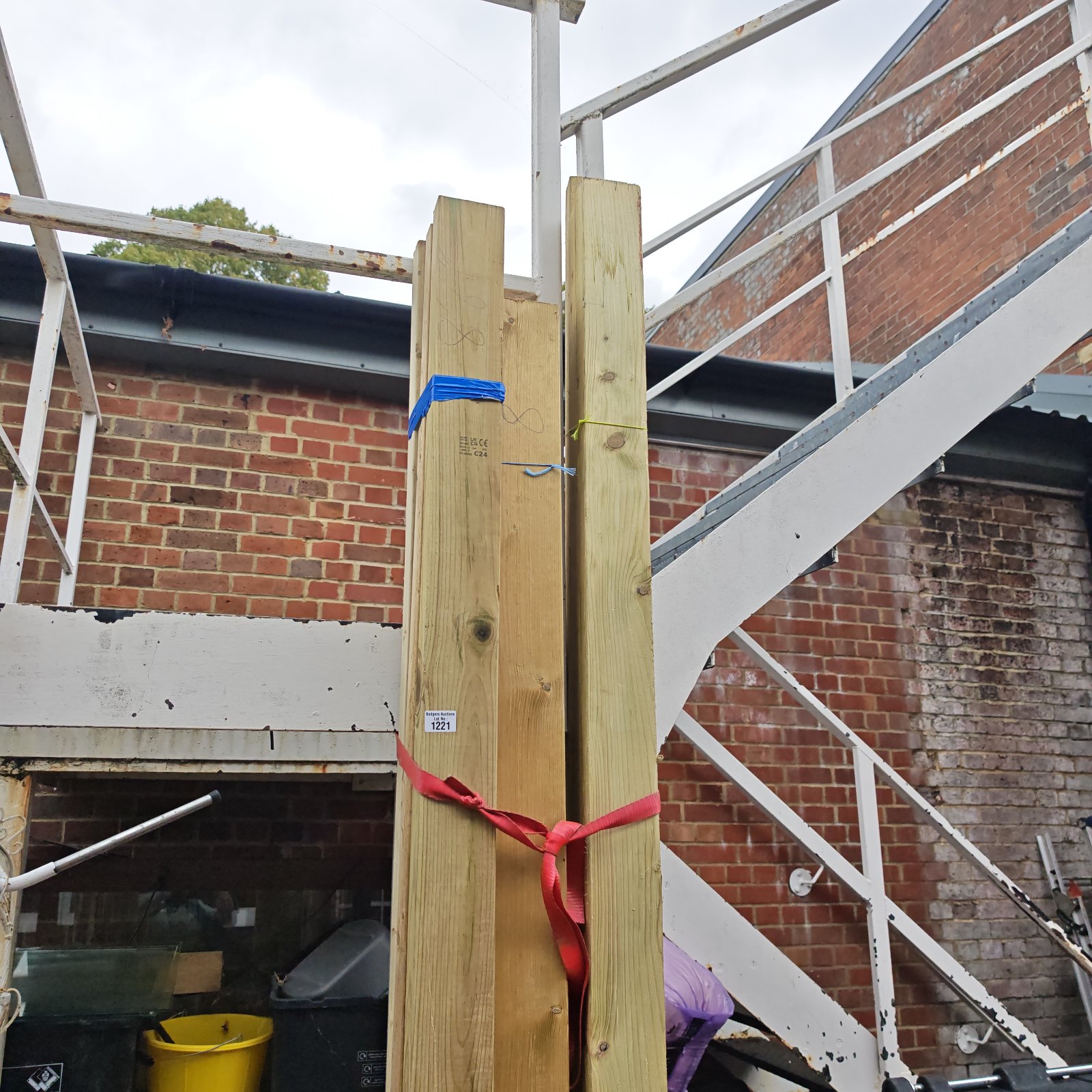 Three bundles of 8ft+ timber secured with straps, ready for construction.