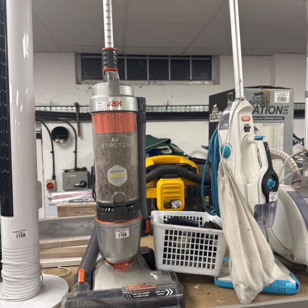 Vax Air Stretch vacuum cleaner with accessories on a shelf.