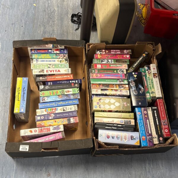 Lot of vintage VHS movie tapes in cardboard boxes.
