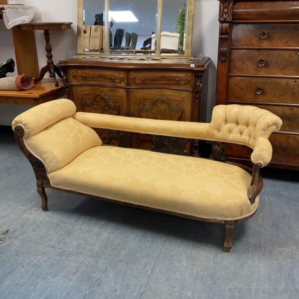 Victorian chaise lounge with gold floral fabric and harp back.