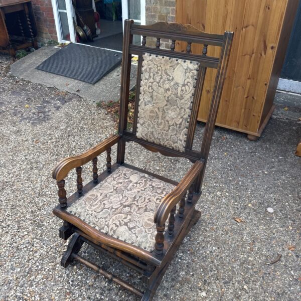 Vintage American rocking chair with upholstered seat and wooden frame.