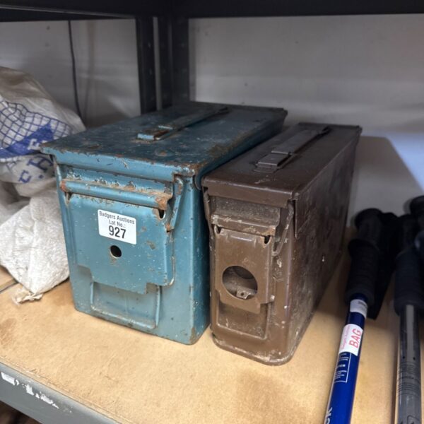 Vintage steel ammo tins with hinged lids, showing signs of wear.