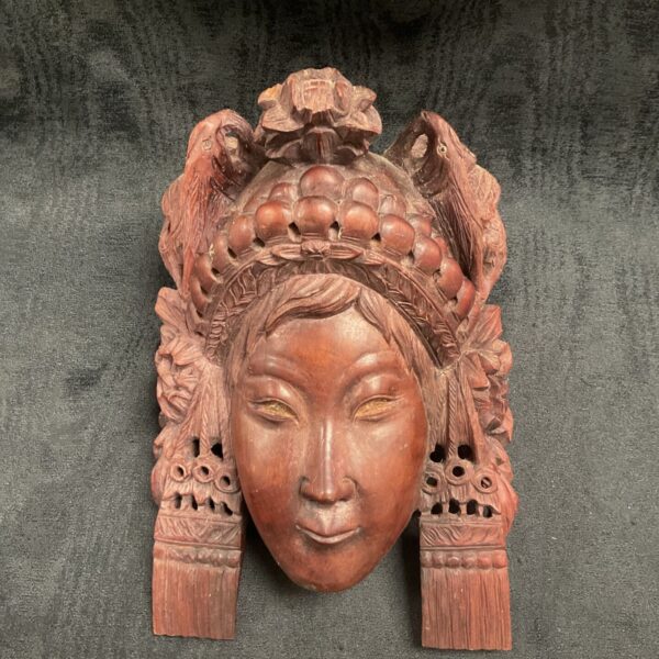 Vintage Asian wood mask with detailed carving and headdress.