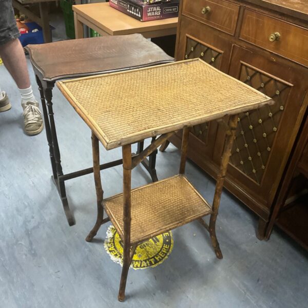 Vintage bamboo side table with woven cane tiers.