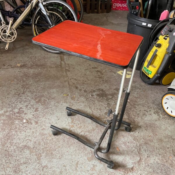 Vintage bedside table with a red laminate top and metal frame.