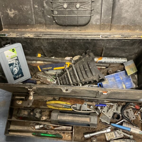 Vintage black toolbox filled with assorted old tools.