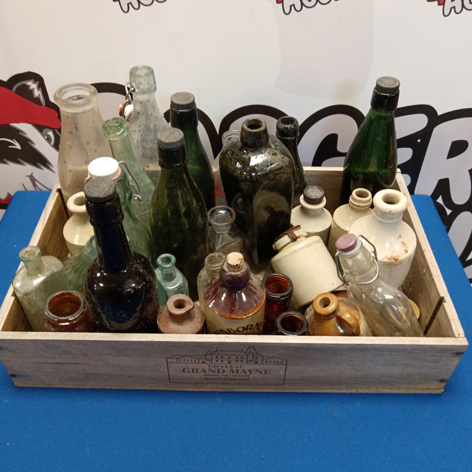 Vintage bottle collection in a wooden crate, antique glass and stoneware.