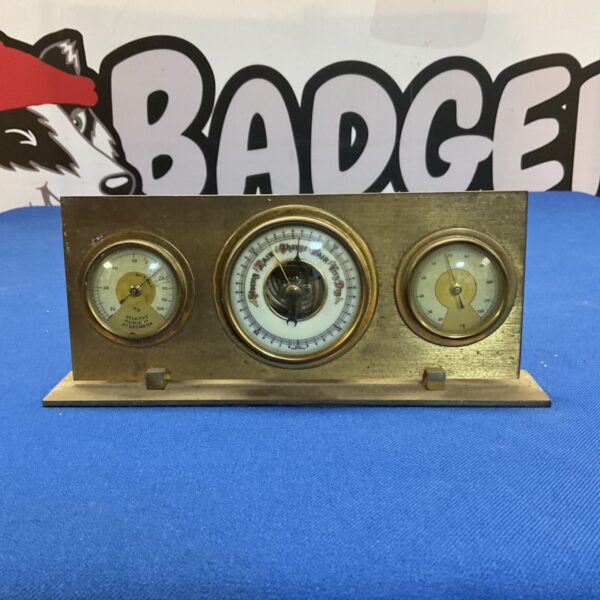 Vintage brass desk barometer with millibar dial for weather readings.